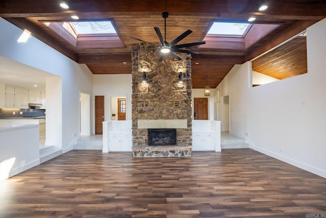 unfurnished living room featuring a skylight, wooden ceiling, and a fireplace