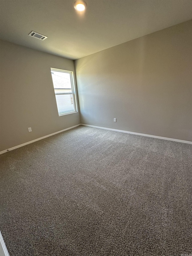 carpeted spare room with baseboards and visible vents