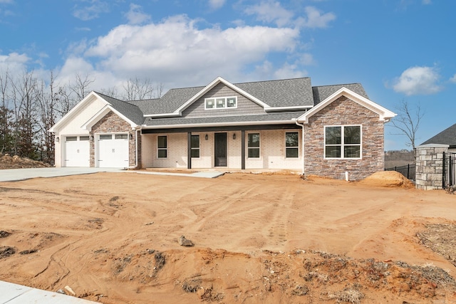 craftsman-style home with an attached garage, a porch, roof with shingles, stone siding, and driveway