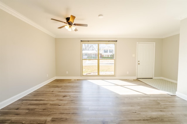 unfurnished room featuring ornamental molding, a ceiling fan, baseboards, and wood finished floors