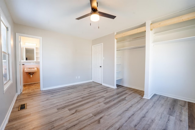 unfurnished bedroom featuring baseboards, visible vents, a ceiling fan, light wood-type flooring, and a closet