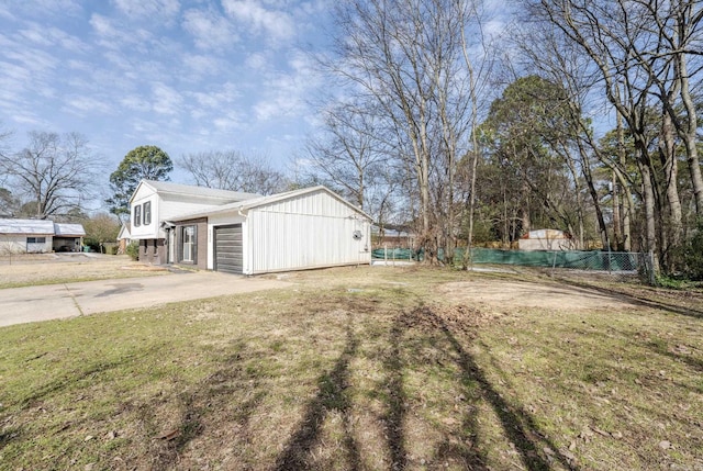 view of yard with driveway, a garage, and fence