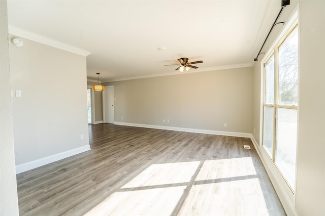 unfurnished room featuring light wood-style flooring, baseboards, ceiling fan, and crown molding