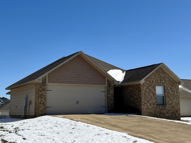 ranch-style home featuring brick siding, driveway, and an attached garage