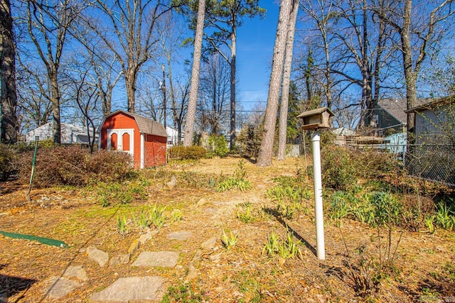 view of yard featuring an outdoor structure, fence, and a shed