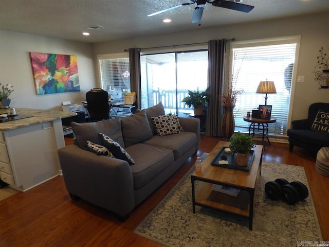 living area with a ceiling fan, recessed lighting, a textured ceiling, and wood finished floors