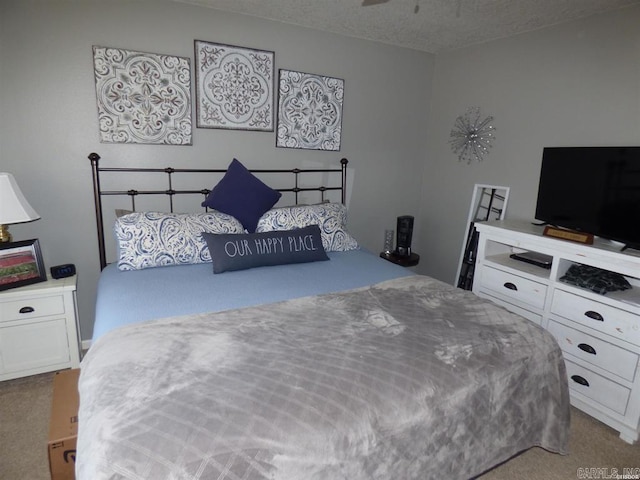 bedroom featuring a textured ceiling and light colored carpet