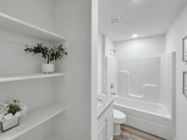 full bath with visible vents, toilet, wood finished floors, tub / shower combination, and vanity