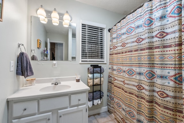 bathroom featuring a textured ceiling, curtained shower, vanity, and tile patterned floors