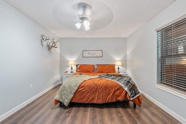 bedroom with baseboards, dark wood finished floors, and a textured ceiling