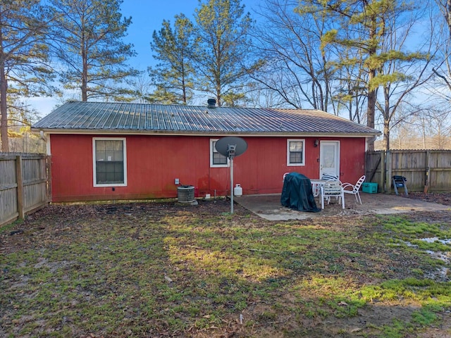 back of house featuring central air condition unit, a patio area, a fenced backyard, and metal roof