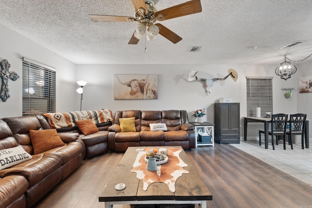 living room featuring visible vents, a textured ceiling, and wood finished floors