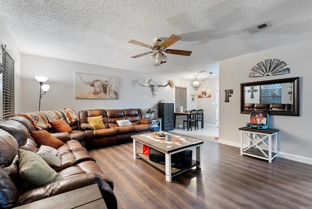 living area with a ceiling fan, wood finished floors, visible vents, and baseboards