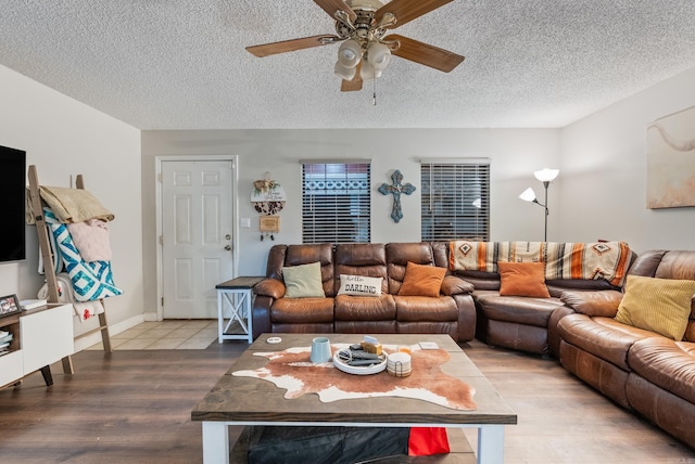 living room featuring ceiling fan, a textured ceiling, and wood finished floors