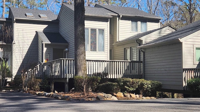 view of property exterior with a shingled roof