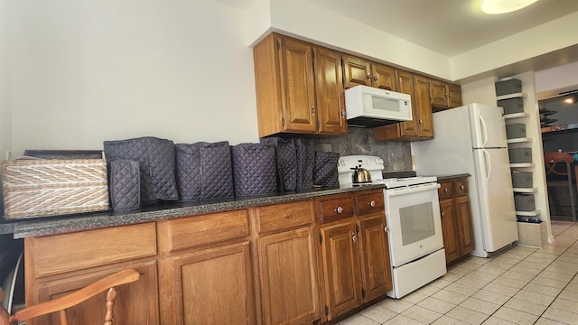 kitchen with tasteful backsplash, white appliances, brown cabinets, and light tile patterned floors