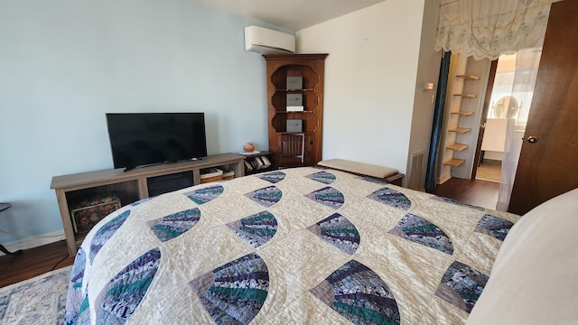 bedroom featuring a wall mounted air conditioner and wood finished floors