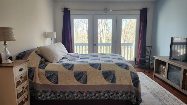 bedroom with dark wood-style flooring, multiple windows, and access to exterior