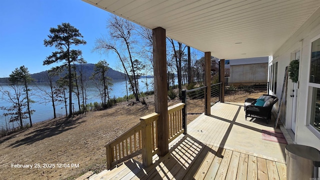 wooden deck featuring a water and mountain view