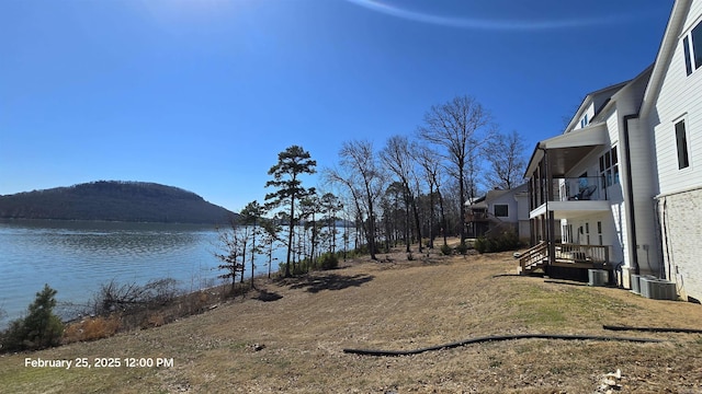 exterior space with central AC, a balcony, and a water and mountain view