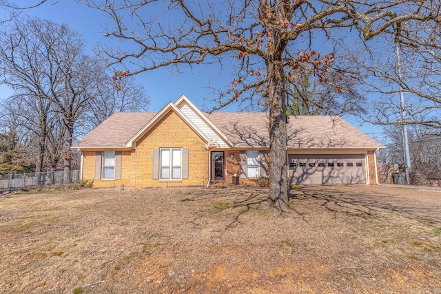 ranch-style home with a garage, a front yard, fence, and brick siding