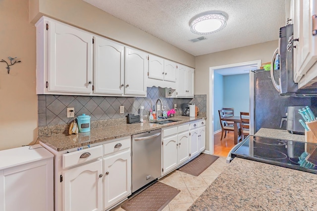 kitchen with white cabinets, visible vents, stainless steel appliances, and a sink