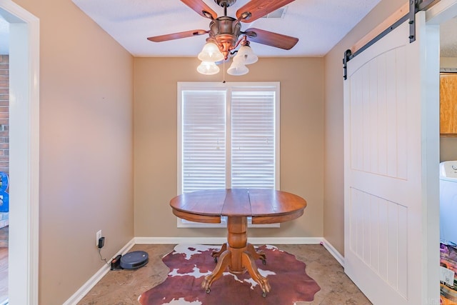 dining room with a wealth of natural light, a barn door, baseboards, and a ceiling fan