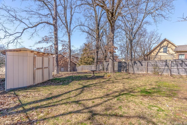 view of yard featuring an outbuilding, a shed, and a fenced backyard