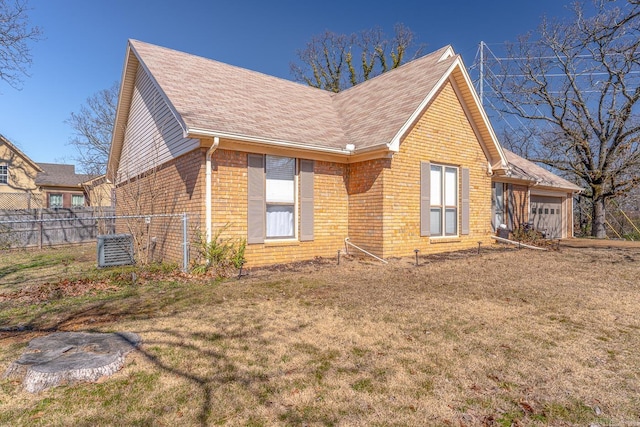 view of front of house featuring a garage, brick siding, a front lawn, and fence