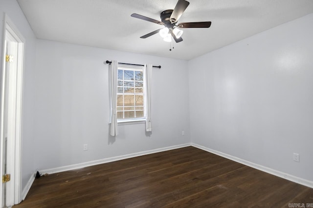 empty room with baseboards, dark wood finished floors, and a ceiling fan