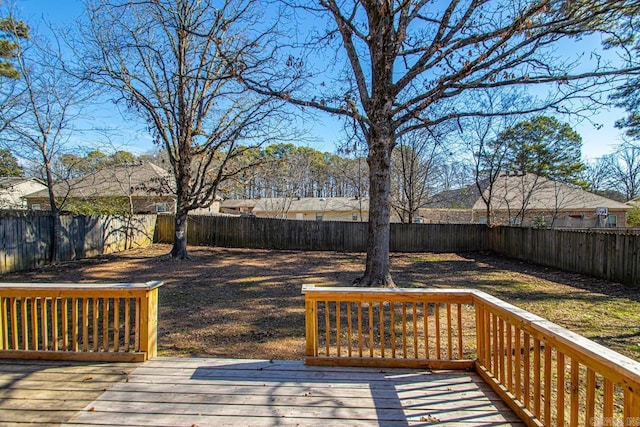 wooden terrace with a fenced backyard