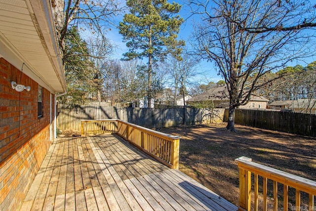 wooden terrace with a fenced backyard