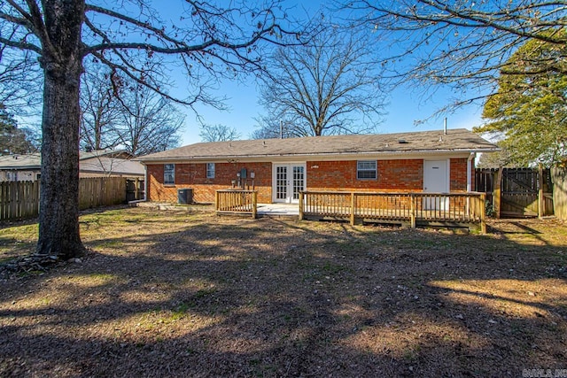 back of house with french doors, brick siding, central AC unit, a deck, and a fenced backyard