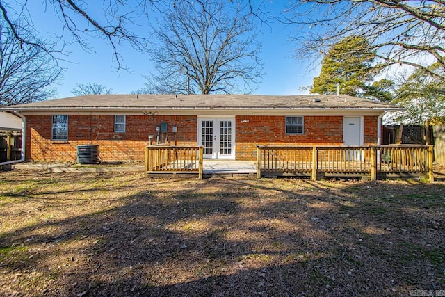 rear view of property featuring french doors, brick siding, a deck, and central air condition unit