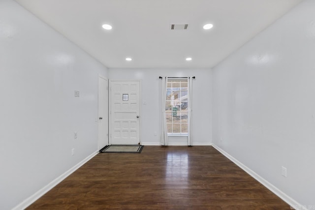 spare room with baseboards, visible vents, dark wood-type flooring, and recessed lighting