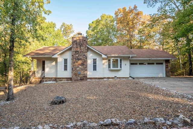 view of front facade with a garage, driveway, and a chimney