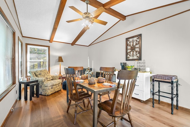 dining space featuring a ceiling fan, baseboards, vaulted ceiling with beams, and light wood finished floors