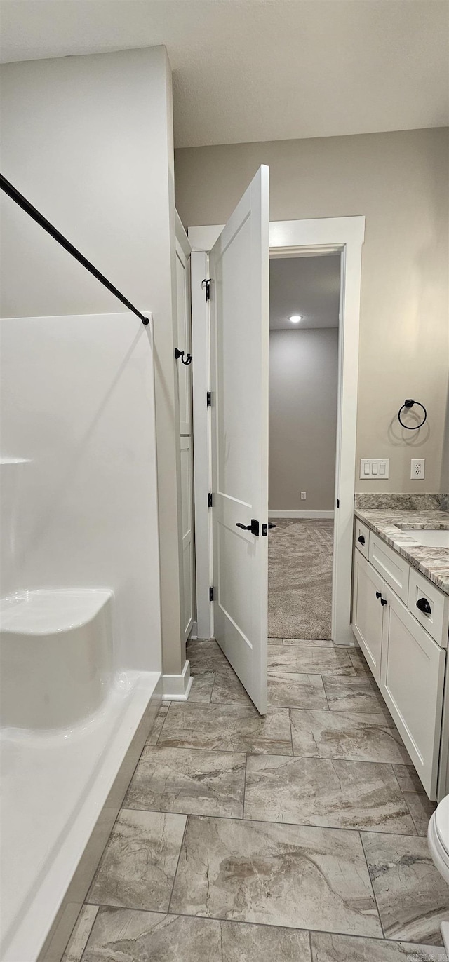 full bath with baseboards, vanity, and toilet