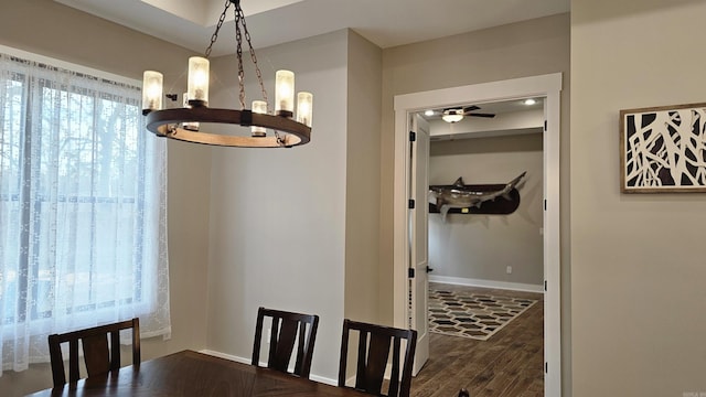 dining area with dark wood finished floors, a ceiling fan, and baseboards