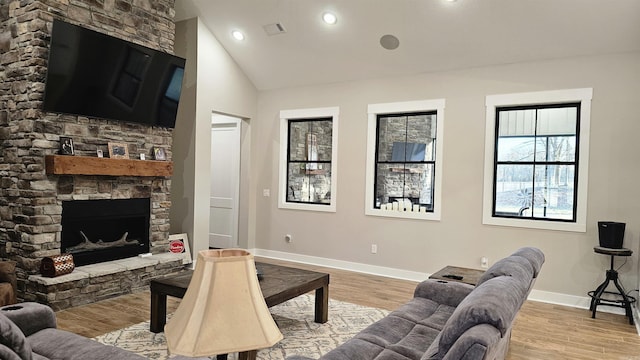 living area featuring a fireplace, light wood finished floors, lofted ceiling, recessed lighting, and baseboards