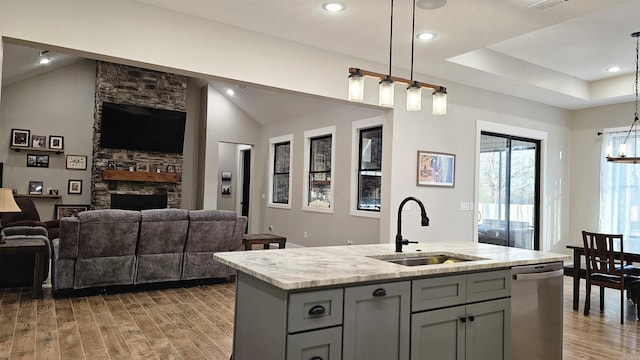 kitchen featuring a center island with sink, dishwasher, open floor plan, hanging light fixtures, and a sink