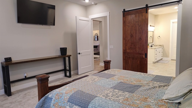 bedroom featuring a barn door, baseboards, and a sink