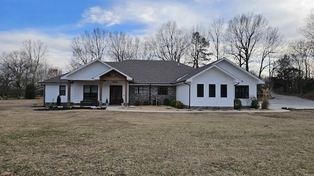 modern farmhouse with roof with shingles and a front lawn