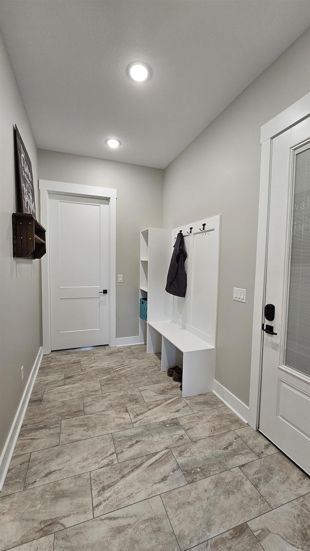 mudroom featuring a textured ceiling, recessed lighting, and baseboards