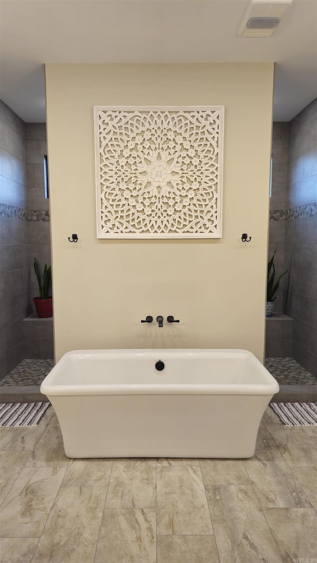 bathroom featuring a soaking tub, visible vents, and a walk in shower