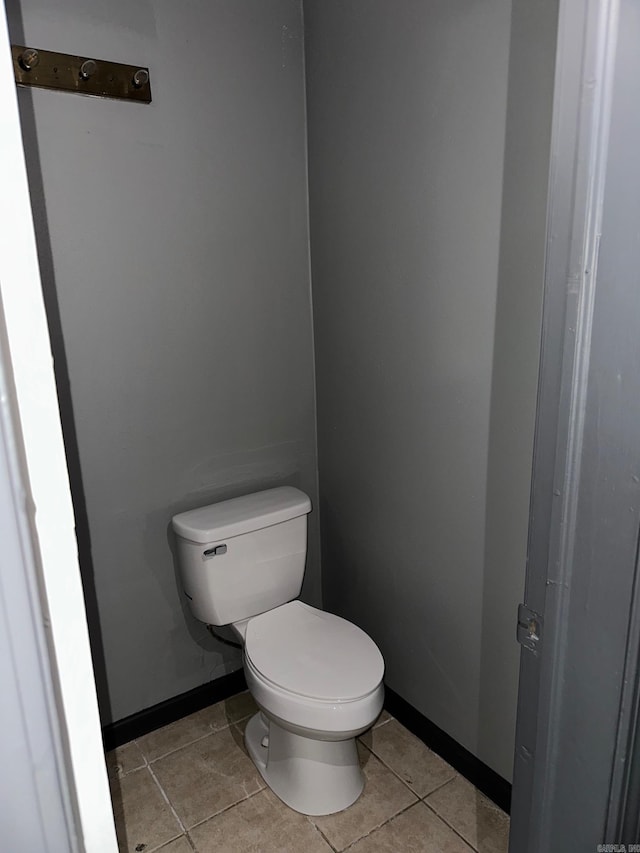 bathroom with toilet, tile patterned flooring, and baseboards