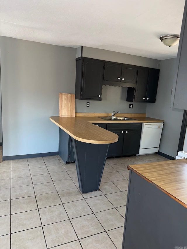 kitchen featuring a breakfast bar, a peninsula, white dishwasher, light countertops, and a sink