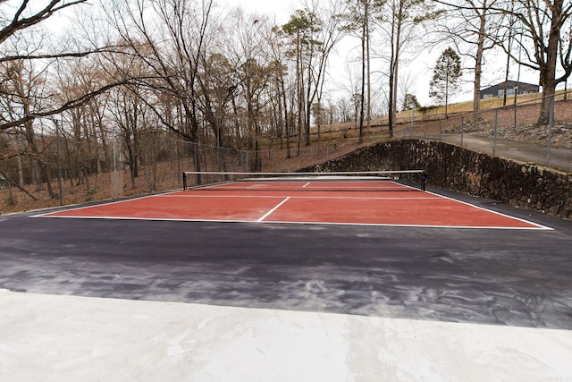 view of tennis court featuring fence