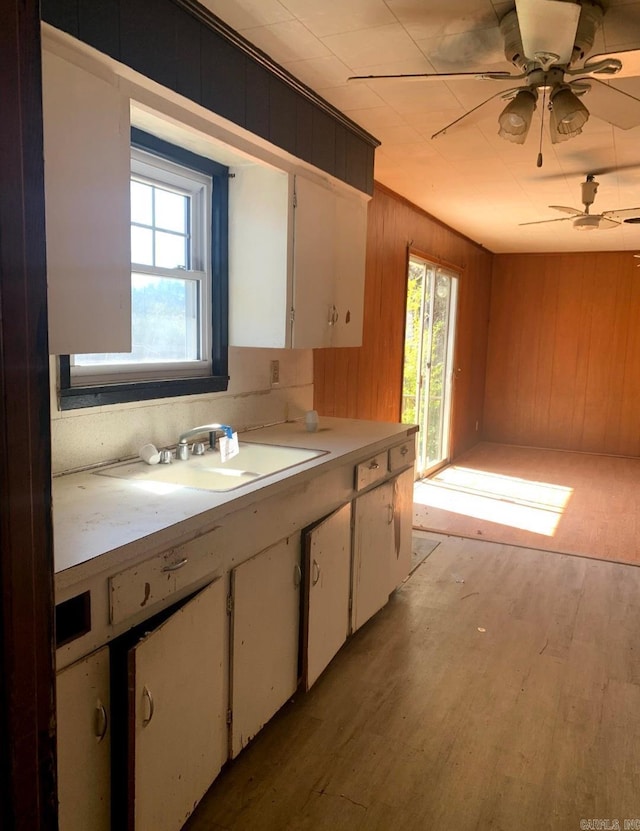 860 Ash St, Prescott, AR 71857 - kitchen with ceiling fan, a sink, light wood-style floors, white cabinets, and light countertops