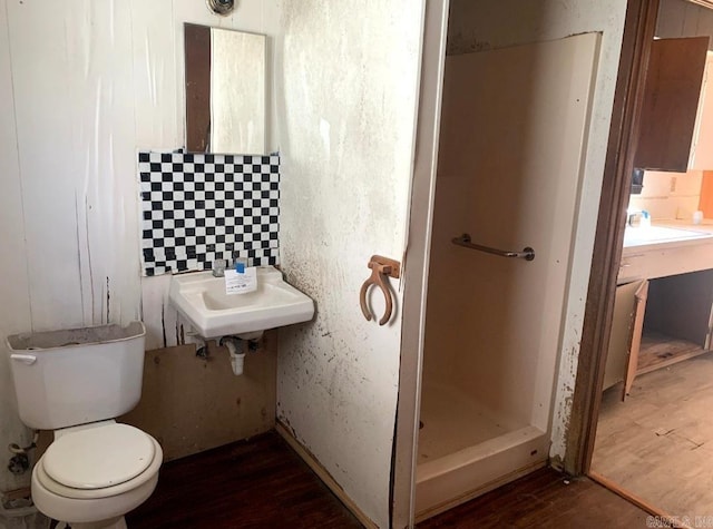 860 Ash St, Prescott, AR 71857 - full bath featuring a sink, a stall shower, wood finished floors, and toilet